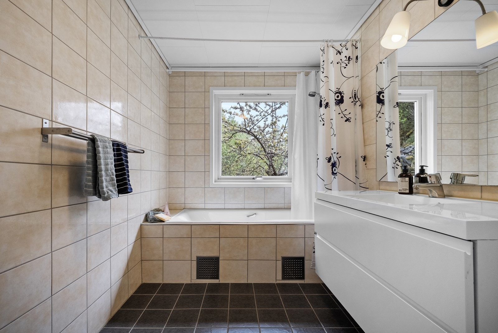 Badet i første etasje har varmekabel i golvet, keramiske fliser og innebygd badekar. Galleribilde