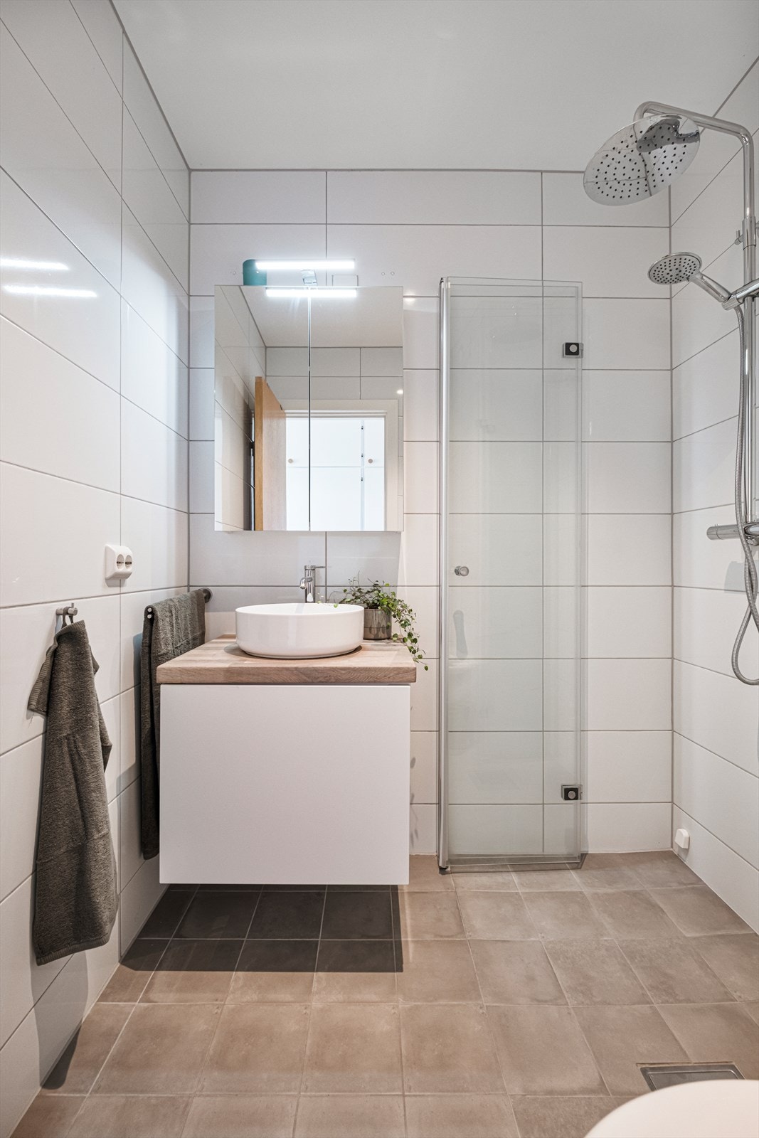 Badet har innredning med servant, vegghengt toalett og dusjnisje med glassdører. Det er elektrisk styrt vifte. Galleribilde