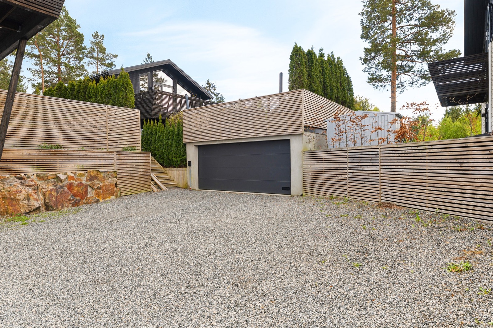Romslig gårdsplass med dobbel garasje på ca. 30 m2. i tillegg er det biloppstillingsplasser (plass til flere biler) på egen tomt. Galleribilde