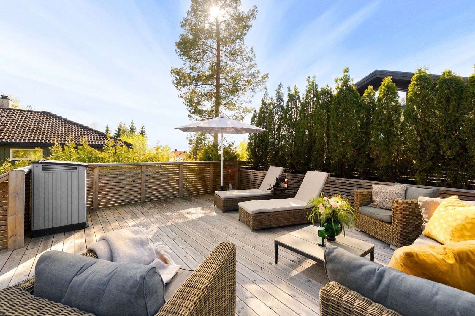 Terrassen er etablert på toppen av en dobbel garasje, hvilket gjør at man kommer opp i høyden. En flott, frodig Tujahekk gjør terrassen både skjermet og privat. Galleribilde