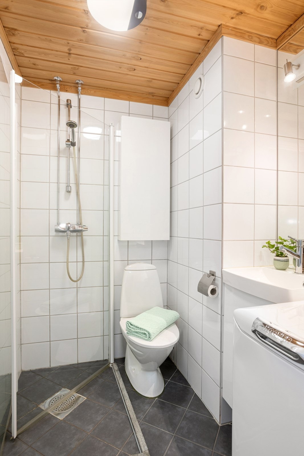 Badet er utstyrt med servant med underskap, toalett, dusjnisje med innfellbare dører, samt opplegg for vaskemaskin Galleribilde