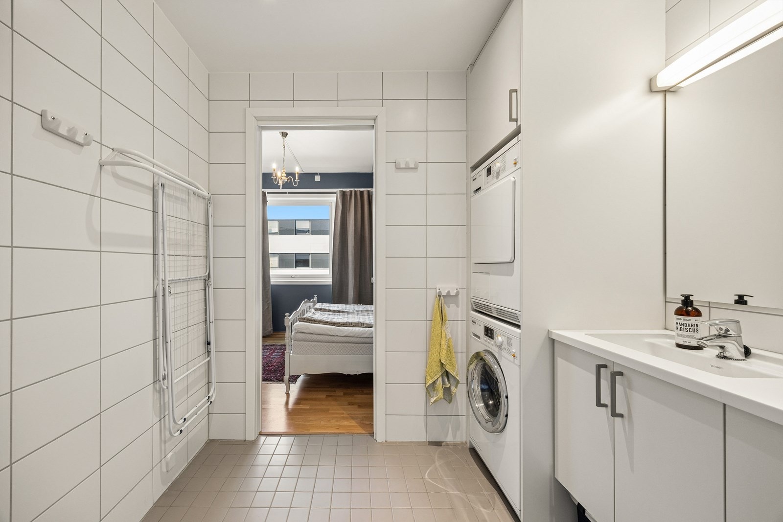 Badet har opplegg for vaskemaskin og tørketrommel, og godt med oppbevaringsplass. Galleribilde