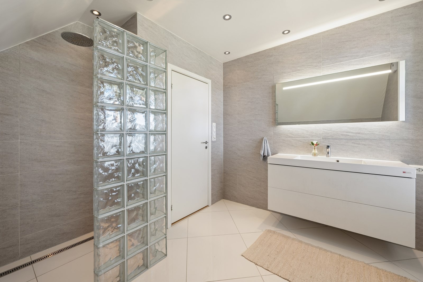 Dusjsonen har slukrenne inntil veggen og en elegant glassbyggervegg. Galleribilde