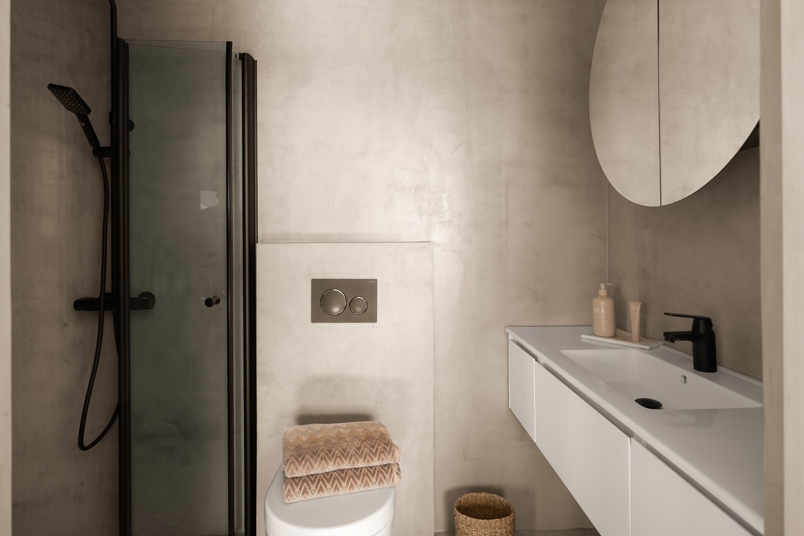 Badet tilknyttet hovedsoverommet har et moderne og stilrent uttrykk med flislagte gulv og mikrosement på veggene. Galleribilde
