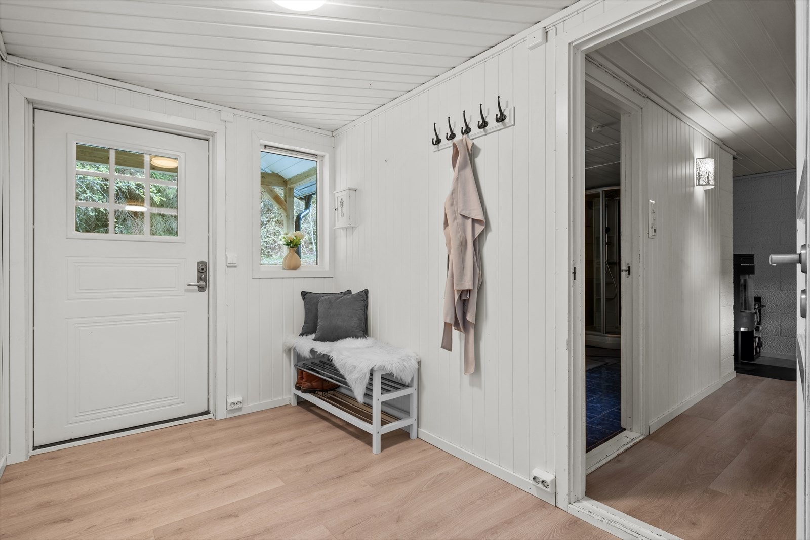 En innbydende entré med nytt gulv i 2026 ønsker deg velkommen inn i boligen. Entréen har god plass for oppheng av klær og sko. Galleribilde