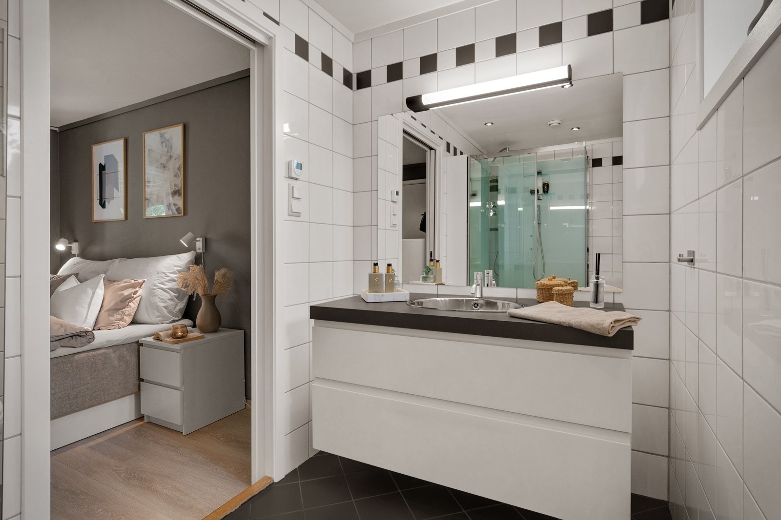 Badet er innredet med nedfelt servant, veggmontert toalett og dusjkabinett. Galleribilde