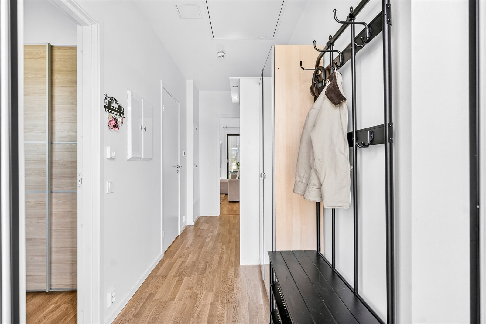 Trappefri adkomst. Entréen gir et moderne førsteinntrykk med gjennomgående parkettgulv og tidsriktige fargetoner som videreføres gjennom boligen. Galleribilde