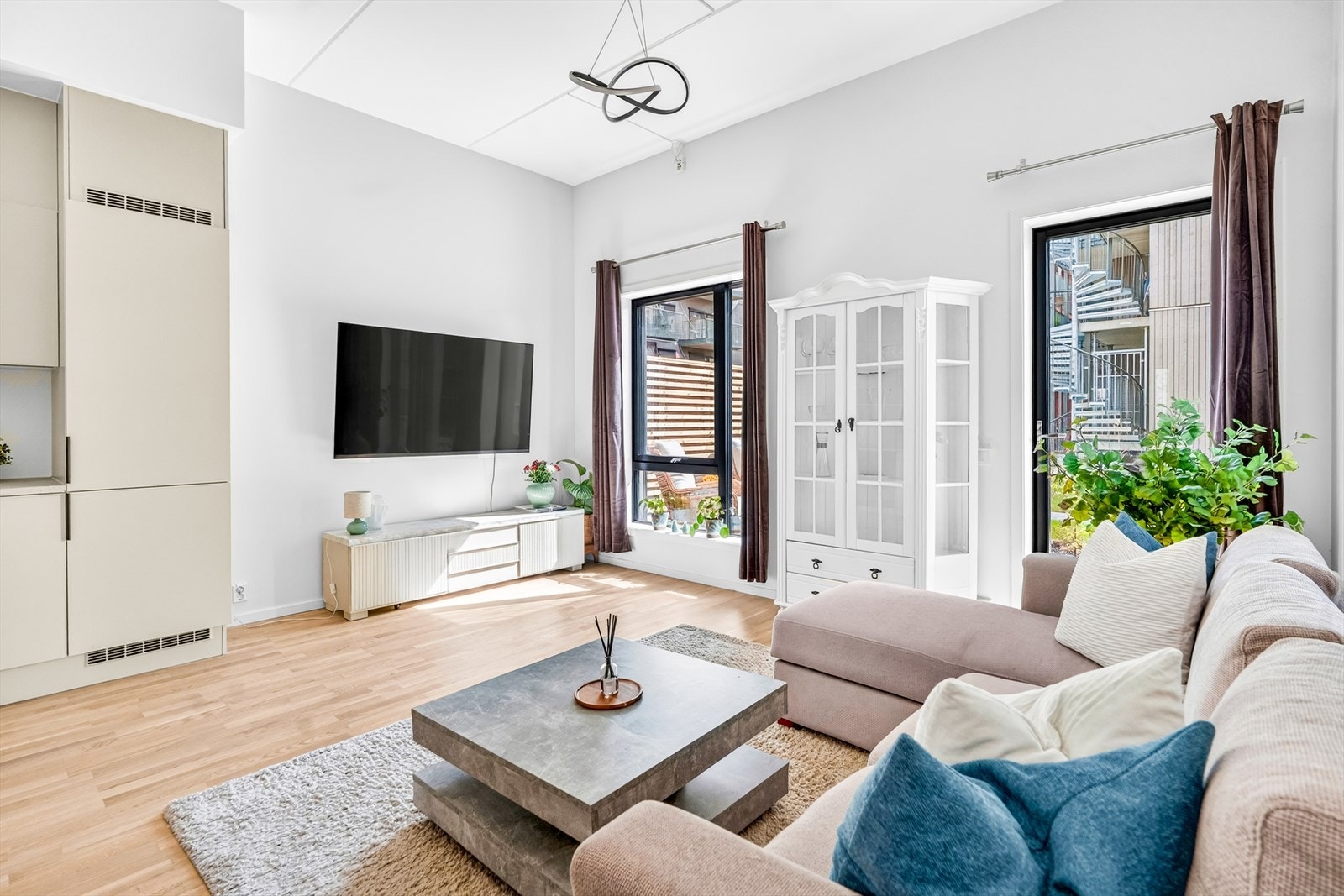Herfra er det utgang til en sydvestvendt uteplass med hyggelig utsyn mot pent opparbeidede fellesområder og gode solforhold. Det er også tilrettelagt for eventuell montering av utvendige screens. Galleribilde