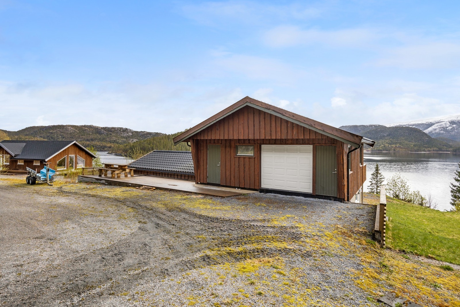 Garasje. Inngangsparti med markterrasse på ca 30 kvm. Port og dør inn til bod på ca 21 kvm. Galleribilde
