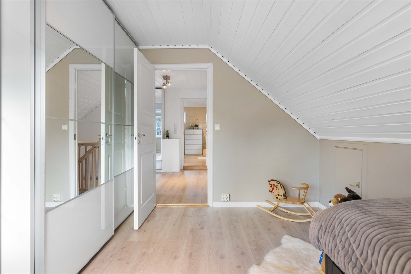 Et stort og godt soverom med rikelig plass til oppbevaring i en skyvedørsgarderobe med speilfronter. Galleribilde