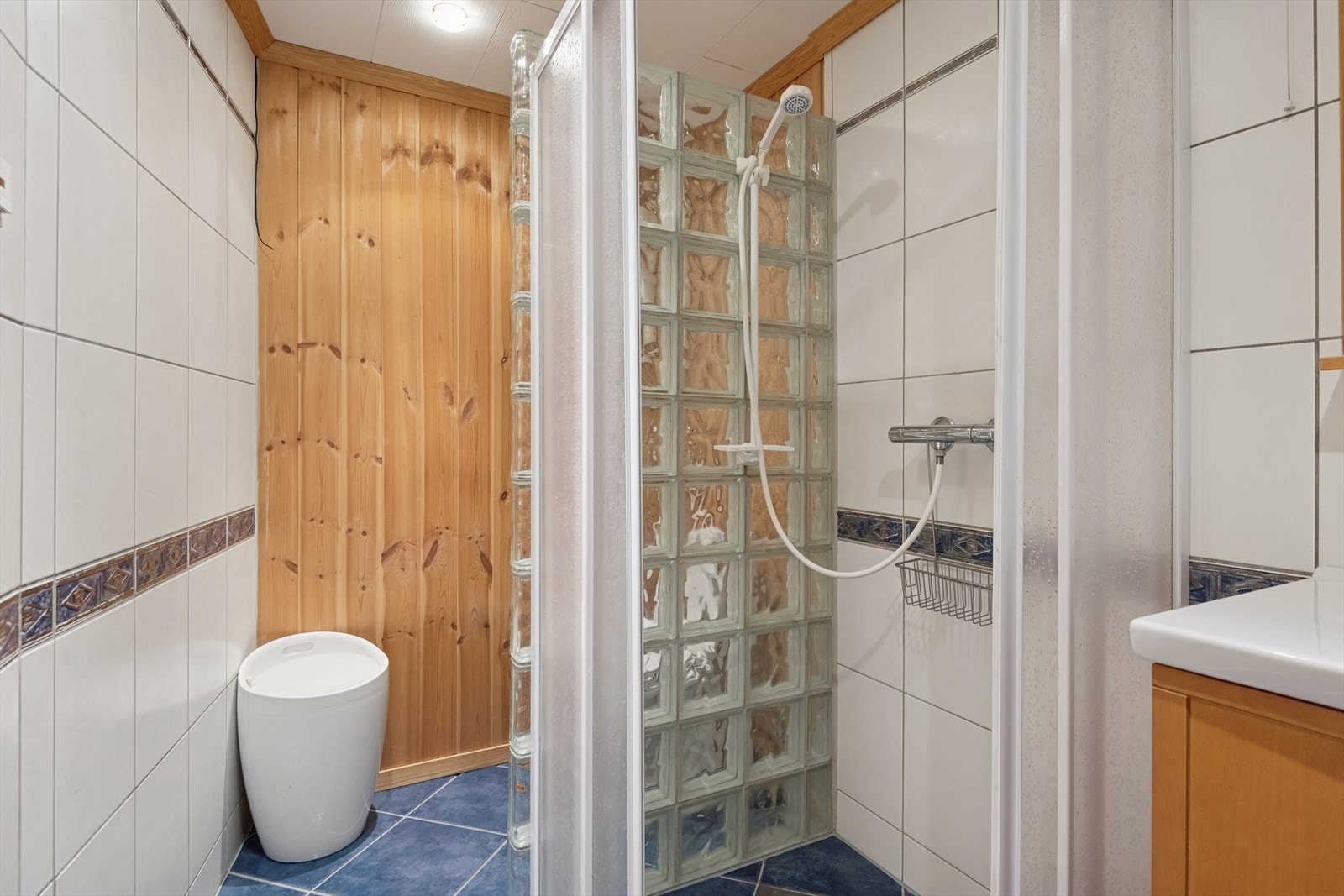 Dette badet har gulvfliser med varmekabler og en kombinasjon av fliser og panel på veggene. ( Ikke godkjent, se punkt under ferdigattest i salgsoppgaven) Galleribilde