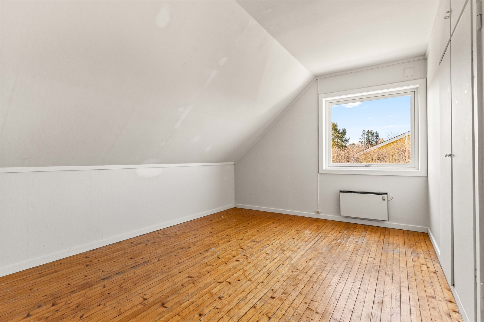 Ett av tre soverom i boligens andre etasje. Rommet har heltre gulv og sjarmerende skråtak. Galleribilde