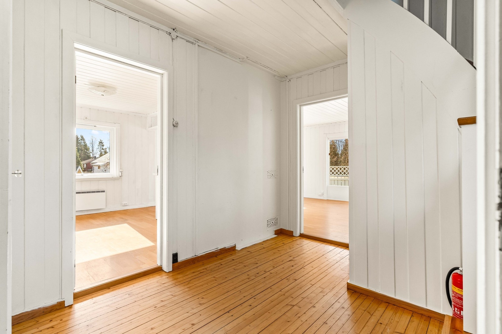 Gangen har heltre gulv og forbinder etasjens rom. Trappen i trekonstruksjon leder opp til andre etasje. Galleribilde