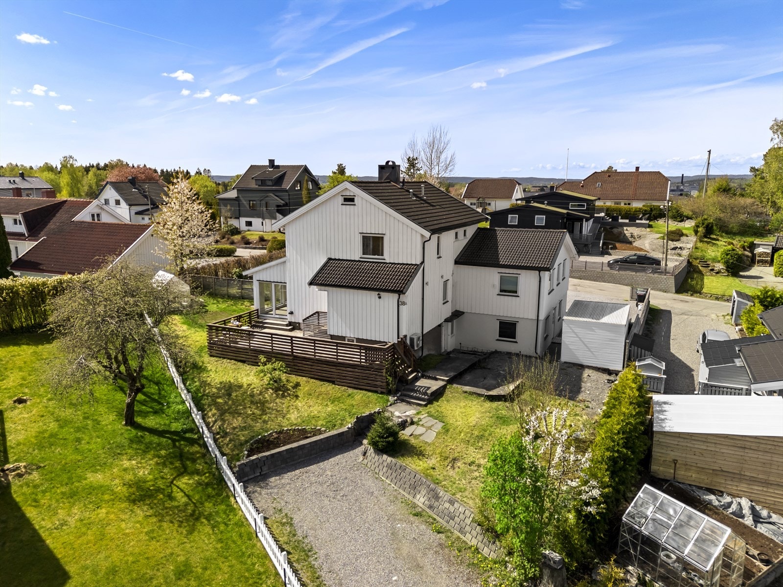 Gruset gårdsplass og opparbeidet hage. Galleribilde