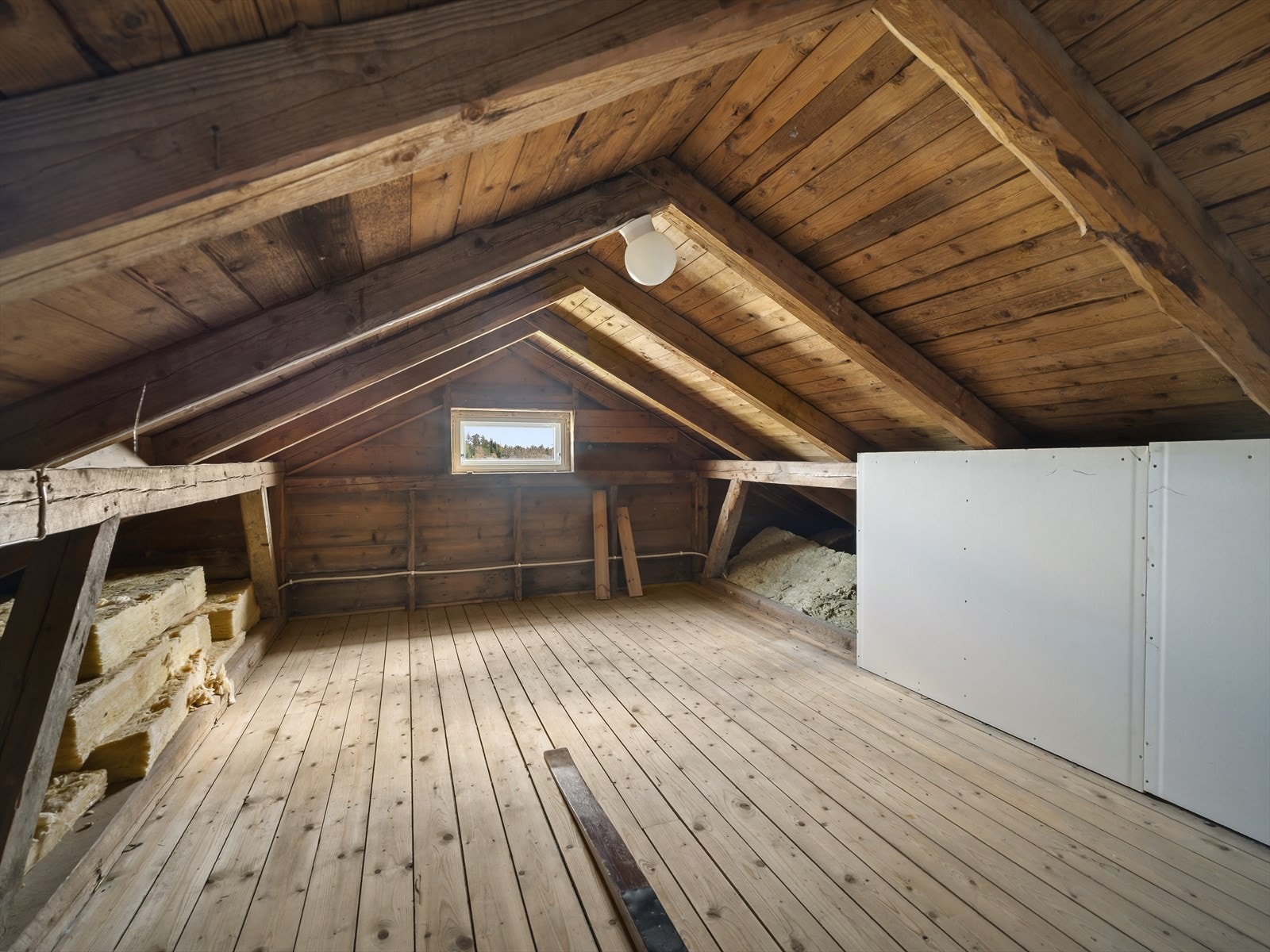 Uinnredet loft med synlige takbjelker og potensial for lagring. Galleribilde
