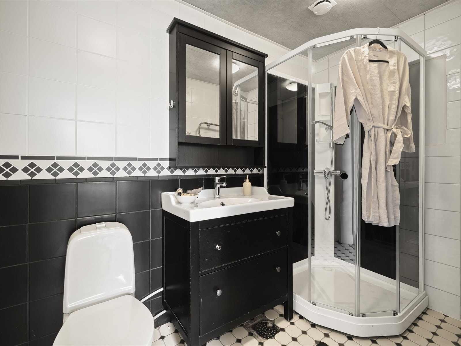 Badet i andre etasje har fliser på gulv og vegger, og er utstyrt med dusjkabinett, toalett og servant. Galleribilde