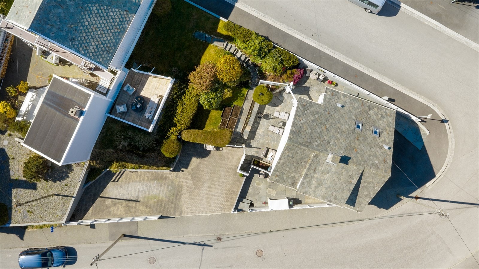 Tomten er effektivt utnyttet med parkering, hage og flere terrasser. Galleribilde
