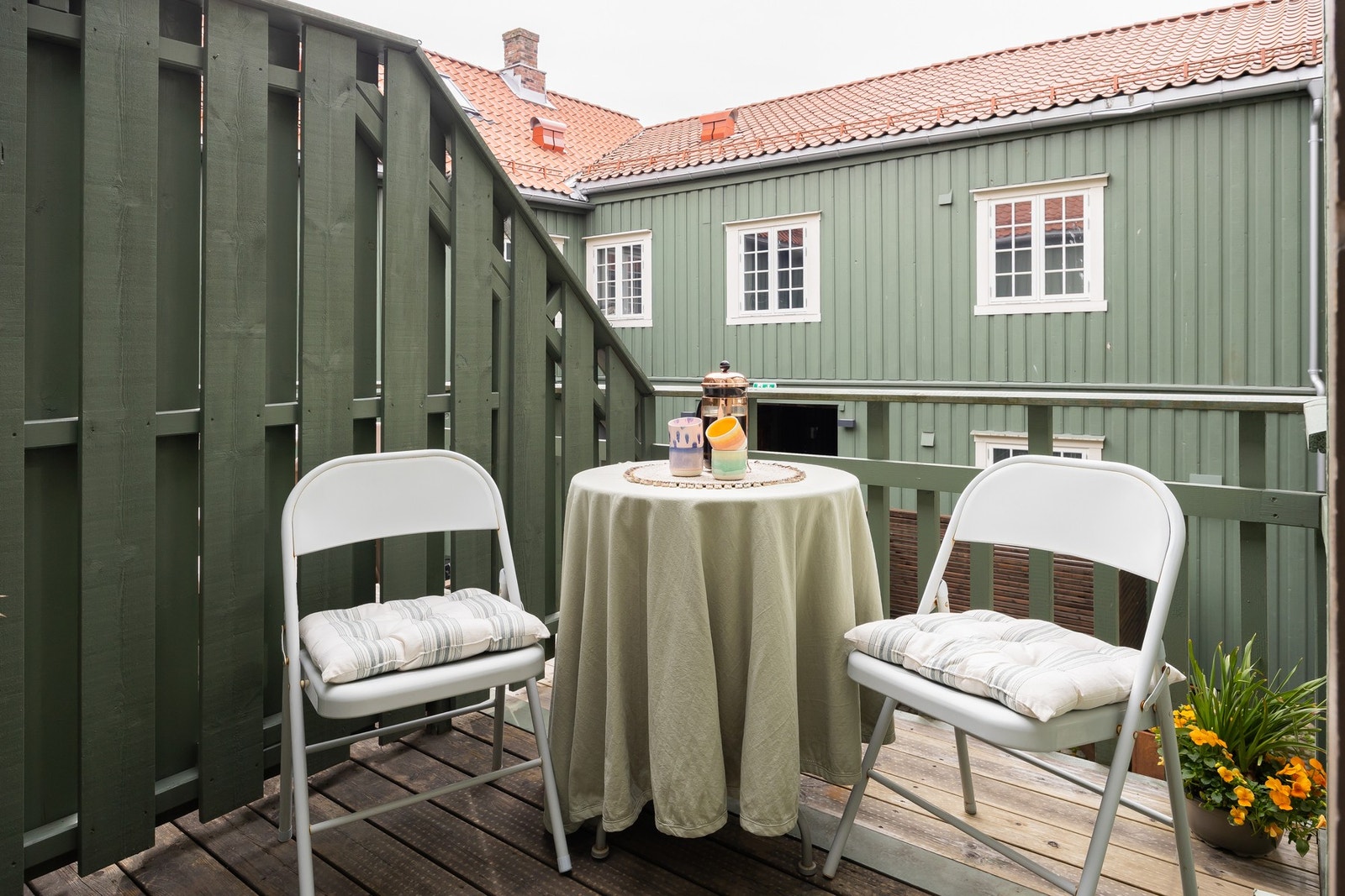 Hyggelig veranda som er sørvendt og vender inn mot et skjermet gårdsrom. Galleribilde