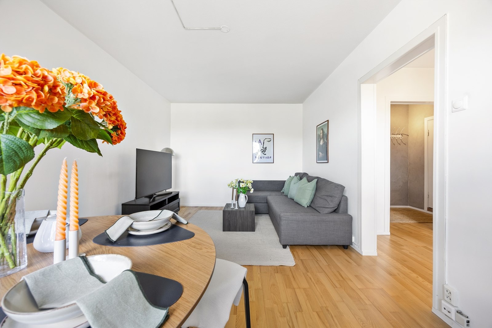 Leiligheten har en lys stue med plass til sofagruppe, mediemøbler og spisebord. Galleribilde