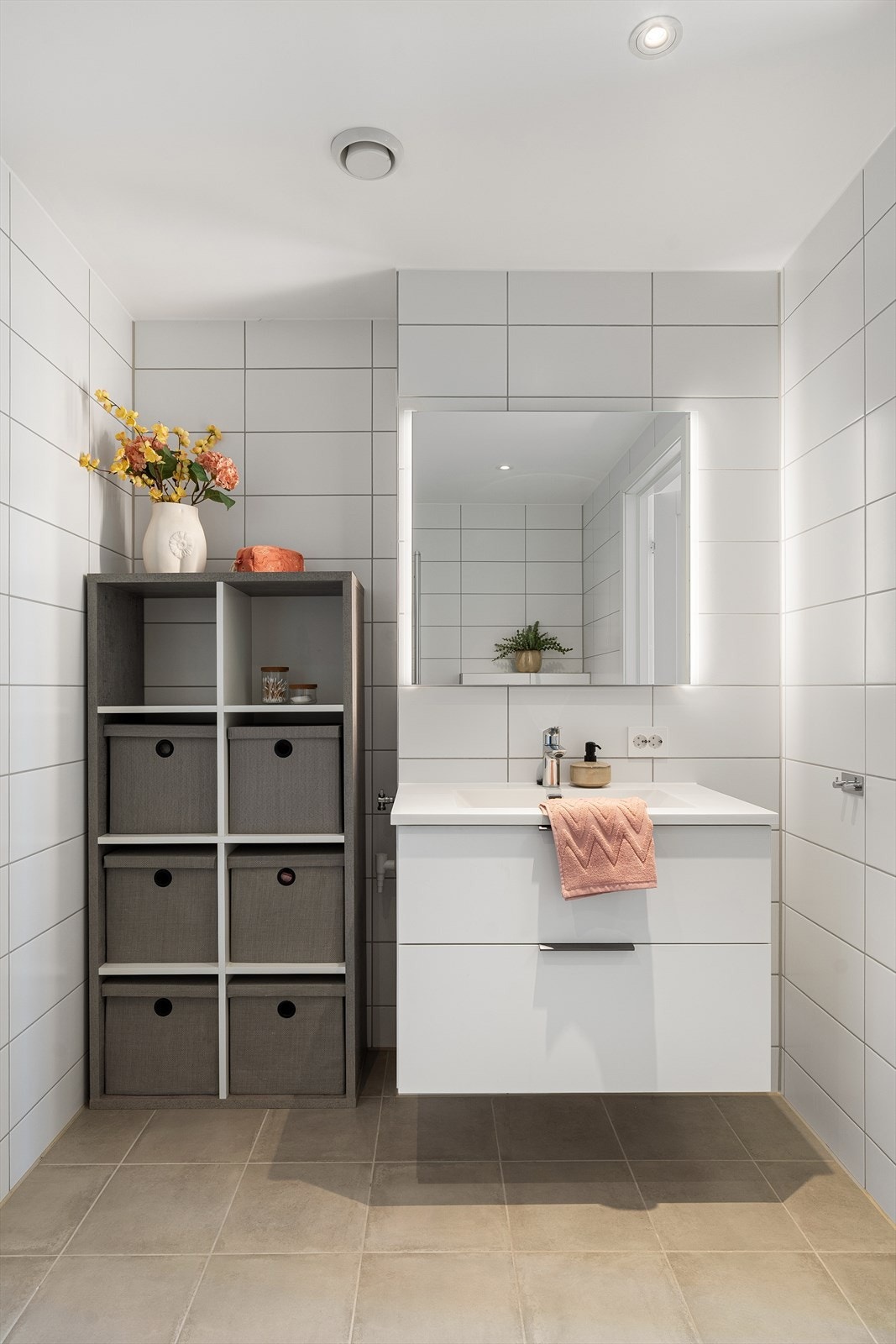 Badet har vegghengt toalett, dusjhjørne med foldbare glassvegger, speil med belysning og god oppbevaringsplass i baderomsmøbel. Galleribilde