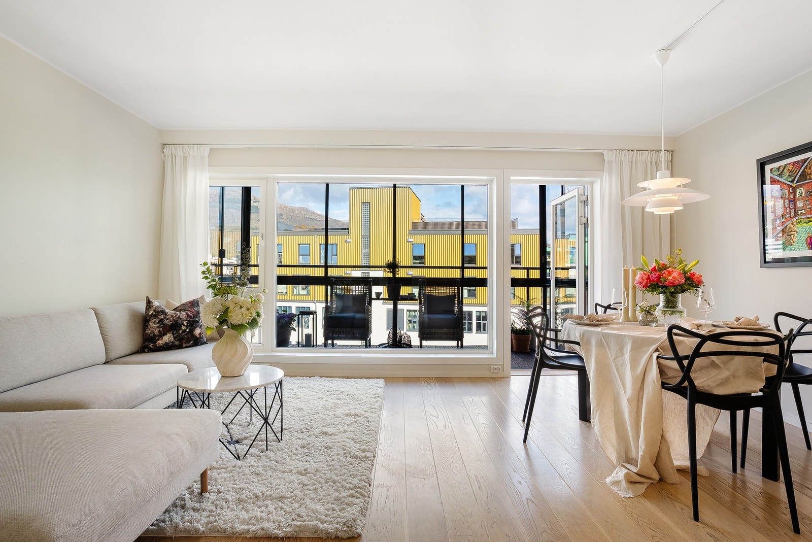 Boligen holder en moderne standard med lyse overflater og store vinduer i front Galleribilde