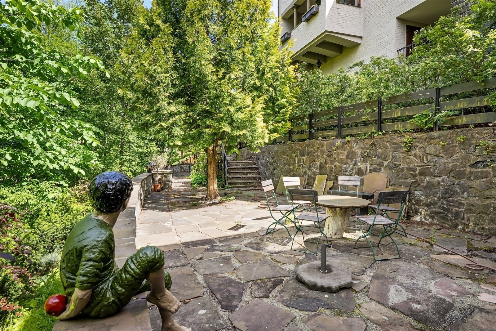 Uteområdene er parkmessig opparbeidet med flere nivåer og skjermet av frodig, grønn beplantning Galleribilde