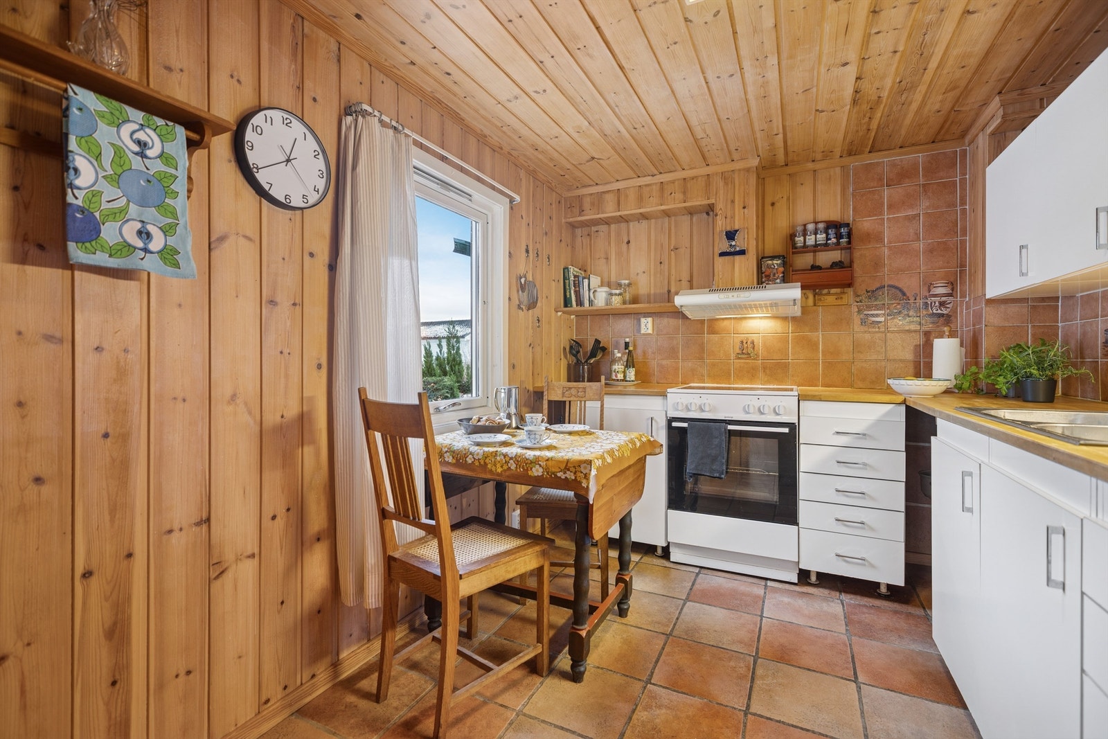 Kjøkkenet har flislagt gulv med gulvvarme og en lys innredning med slette fronter med plass til hvitevarer, og en koselig spiseplass til frokost og små måltider. Galleribilde