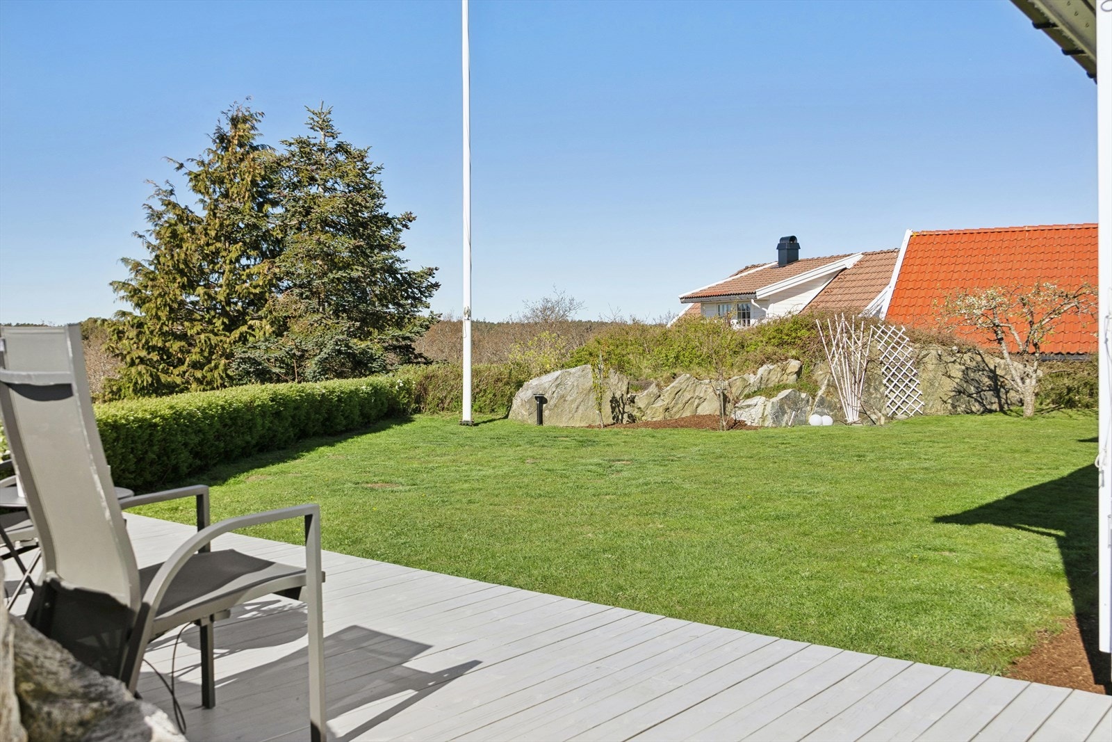 Eiendommen er pent opparbeidet med plen, hekk og diverse beplantning. Galleribilde