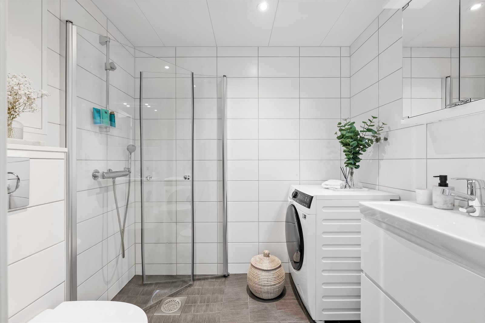 Badet fremstår som delikat og funksjonelt med flislagte overflater som gir et tidløst og lettstelt uttrykk. Galleribilde