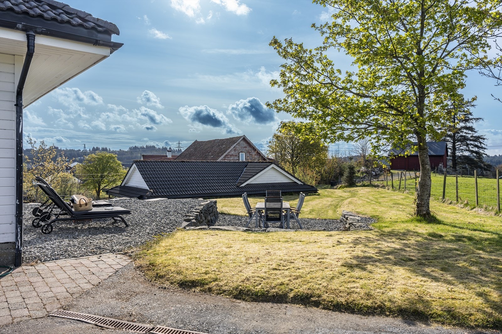 Stor hage og uteområde med flere sitteplasser. Galleribilde