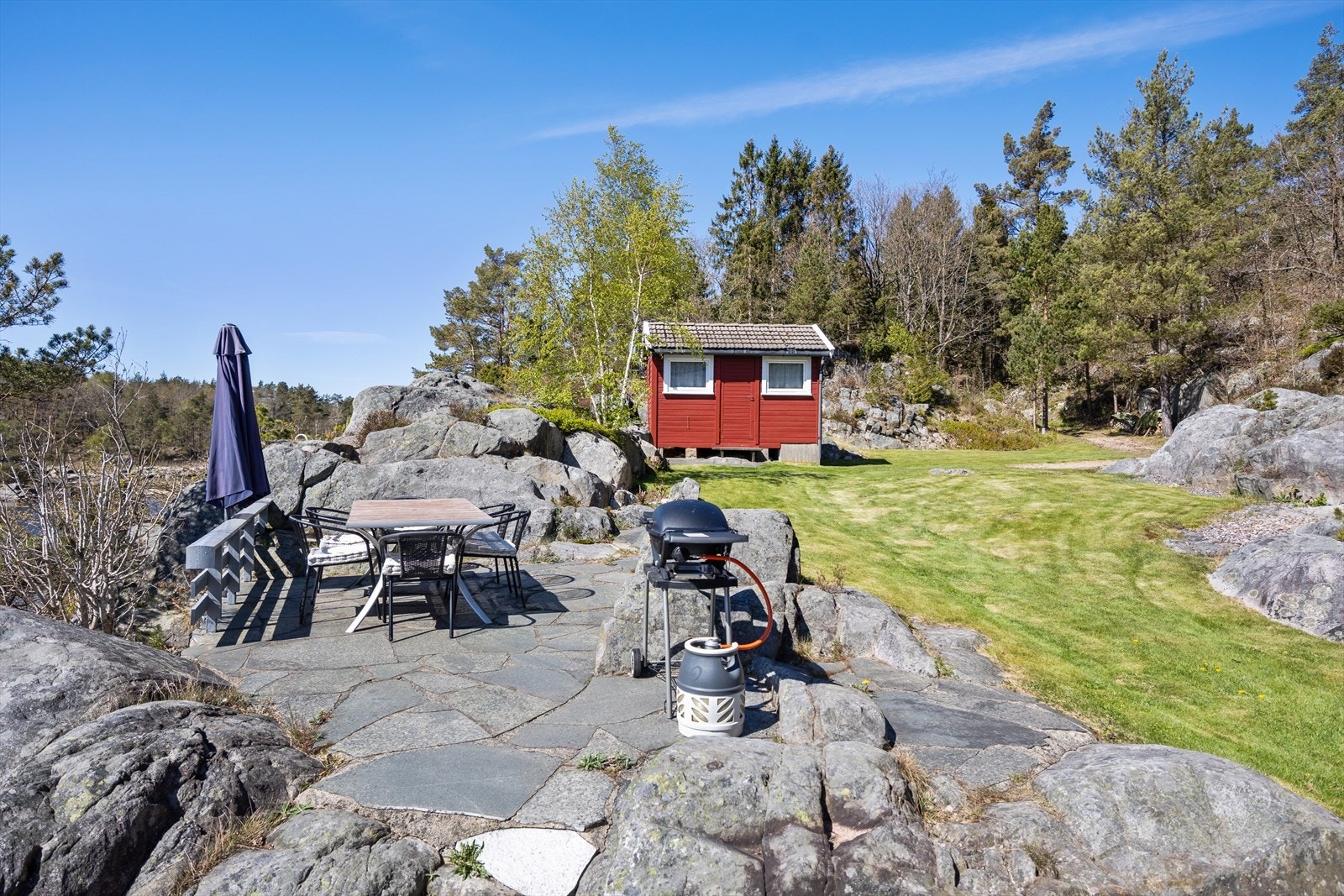Pen hage med skifer platting og fine svaberg. Galleribilde