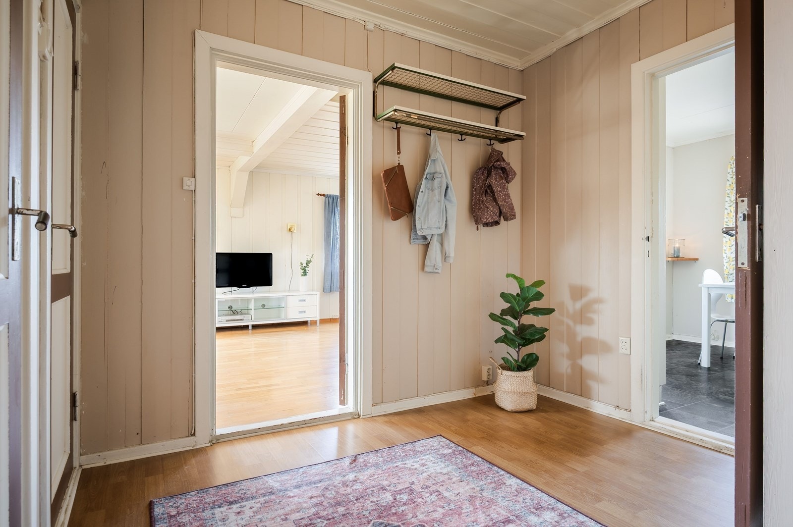 Videre kommer du inn i en romslig gang med plass til sko og oppheng av yttertøy. Det er også et romslig kott med ytterligere lagringsmuligheter. Galleribilde