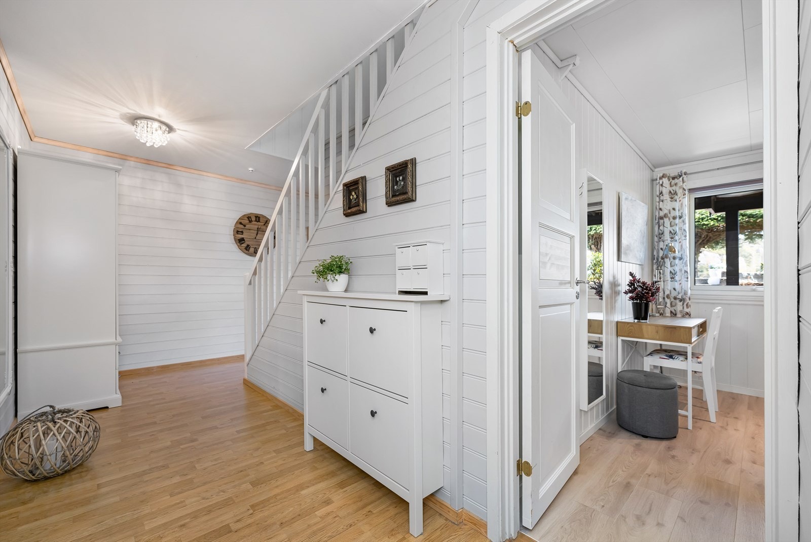 Gangen har laminatgulv og lysmalt panel Galleribilde