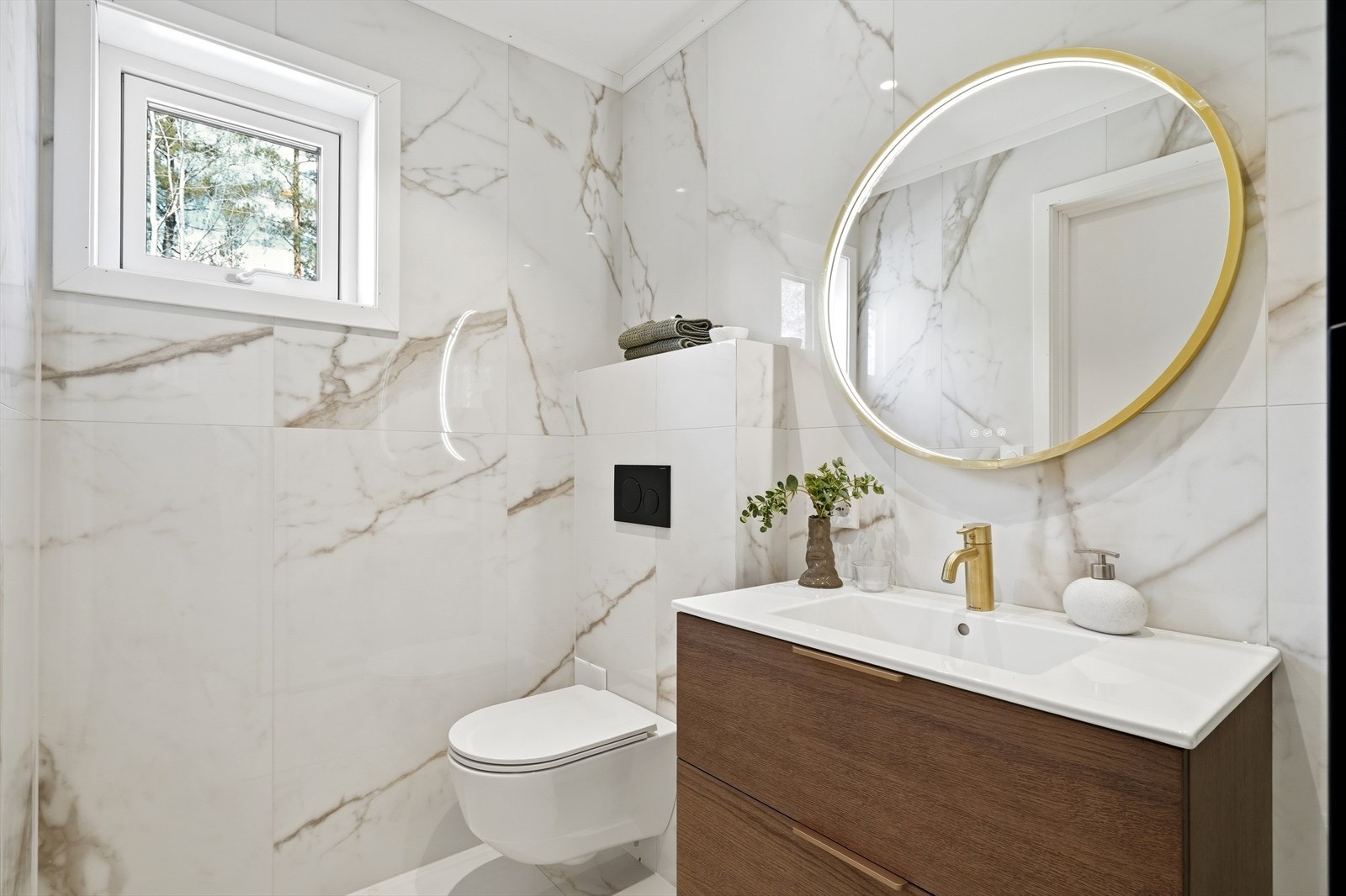Dette stilfulle badet kombinerer tidløs eleganse med moderne materialvalg. Marmorinspirerte fliser gir en sofistikert og luksuriøs følelse, og deres subtile mønster skaper en rolig atmosfære som samtidig tilfører rommet et moderne preg. Galleribilde