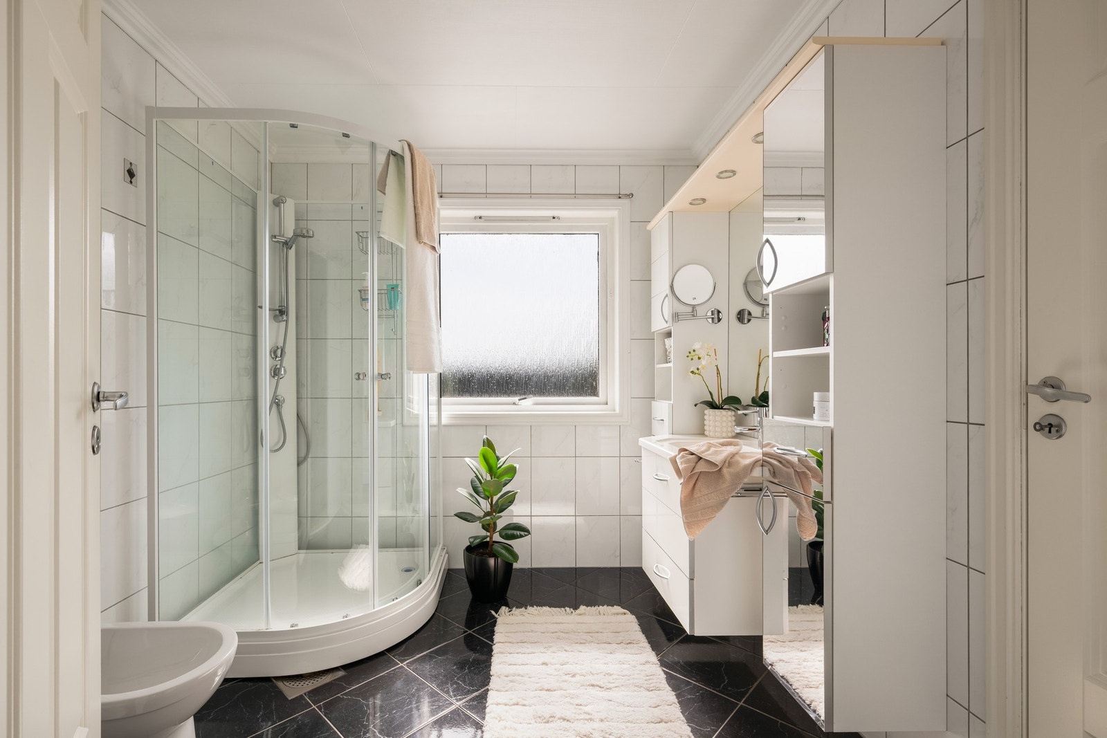 Badet er innredet med nedfelt servant, bide, toalett og dusjkabinett. Galleribilde