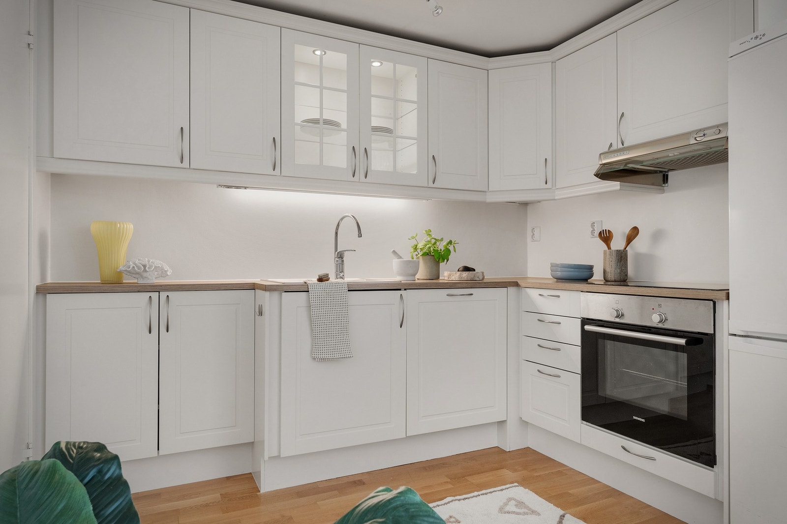 - Kjøkkeninnredning med profilerte fronter, ett overskap har glass front, laminat benkeplate og ventilator - Galleribilde