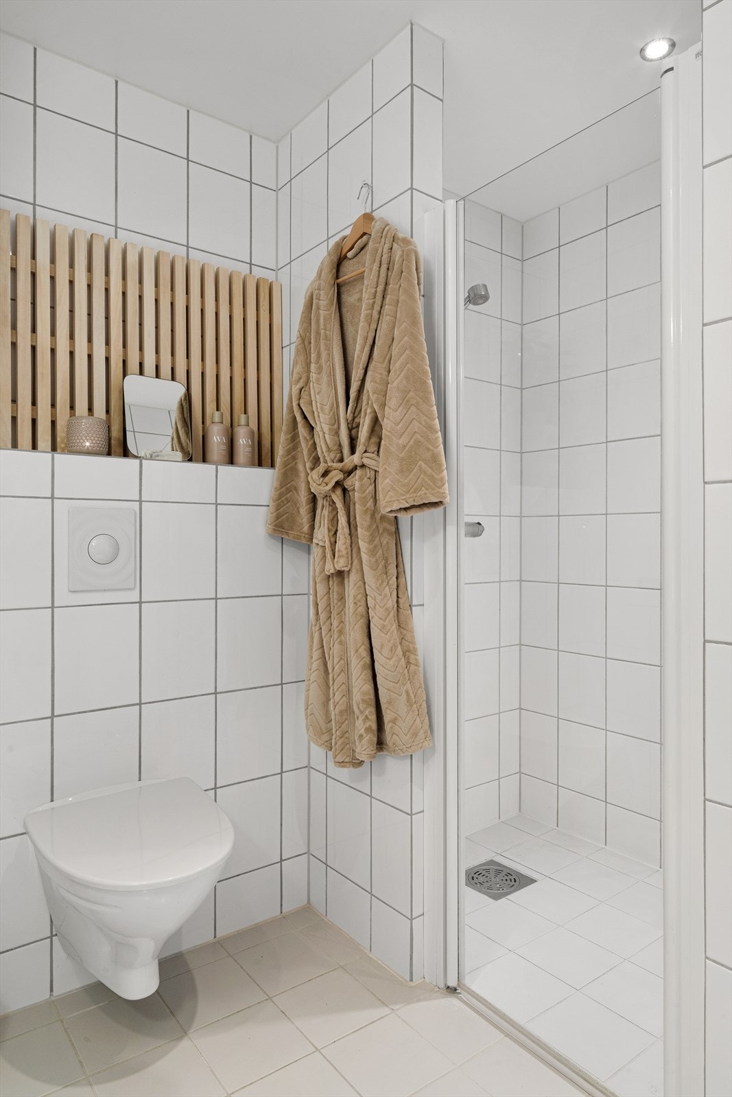 Baderom med moderne flislagte overflater, praktisk dusjløsning og stilrene detaljer som skaper et rent og tidløst uttrykk. Galleribilde