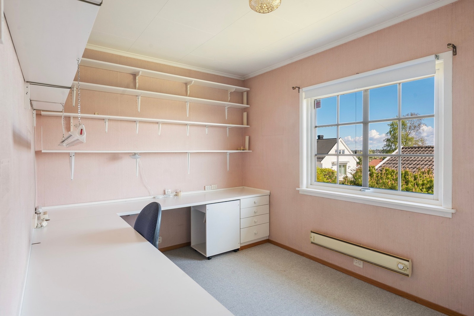 Det andre soverommet i første etasje har også plass til dobbeltseng med nattbord på begge sider, og skap/kommode til oppbevaring. Per nå er rommet innredet med hyllesystemer, og passer utmerket som kontorrom. Galleribilde