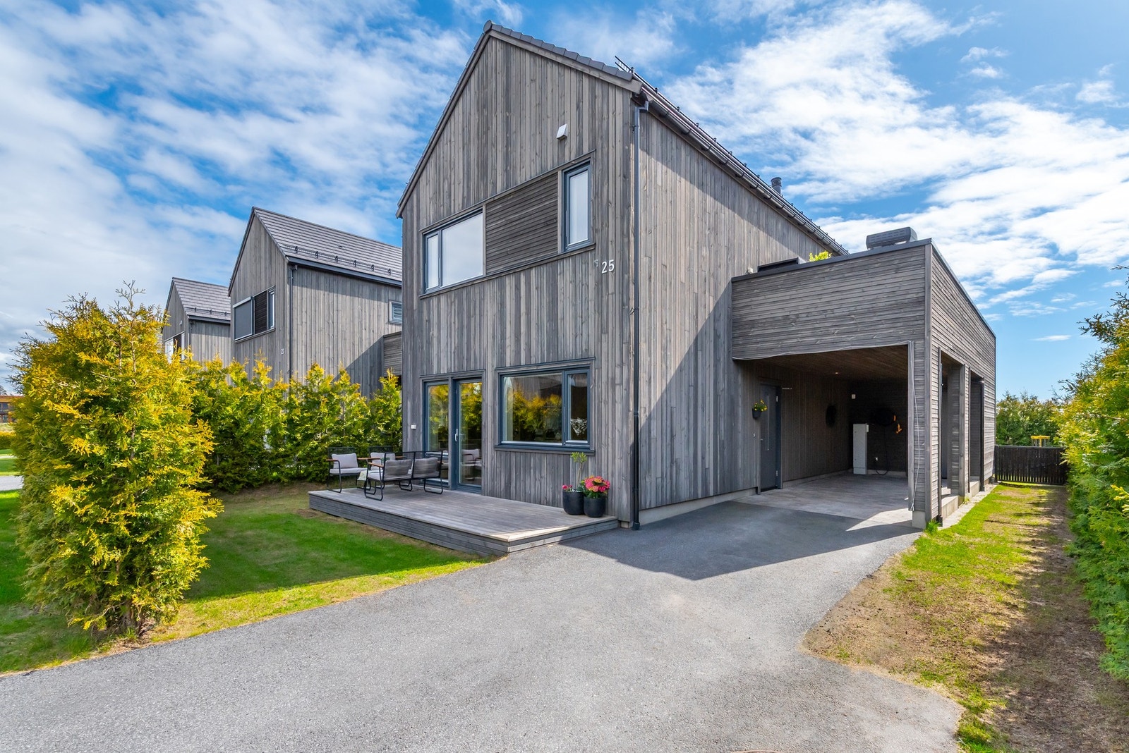 Asfaltert innkjørsel med gode parkeringsmuligheter og carport. Galleribilde