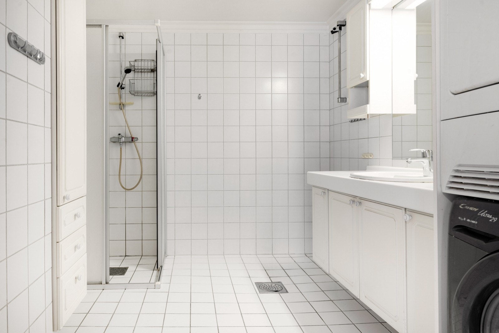 Badet er flislagt og utstyrt med dusjnisje, servantinnredning og opplegg for vaskemaskin. Galleribilde