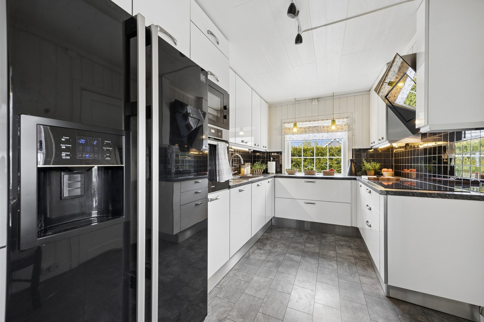 Kjøkkeninnredningen er fra 2010 med hvite fronter i glatt utførelse, laminat benkeplate og utstyrt med Integrert koketopp, komfyr, micro og oppvaskmaskin. Galleribilde