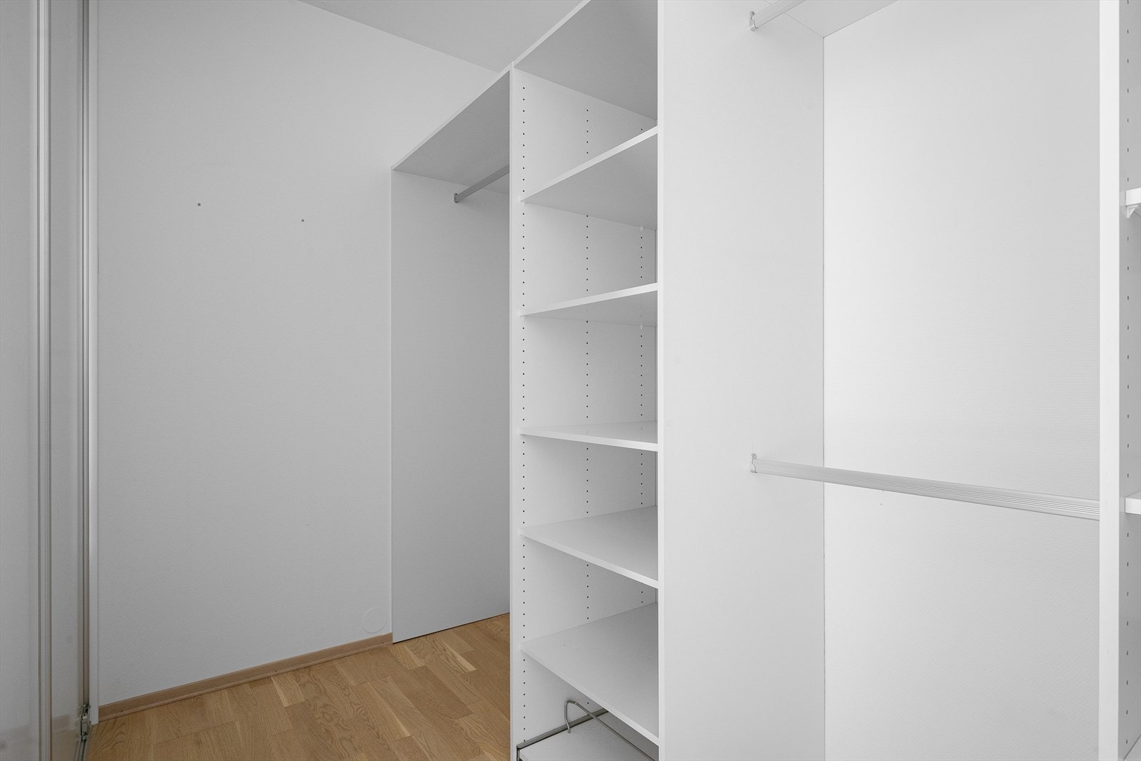 Rikelig med hyller og oppheng i walk in garderobe som du skjuler med skyvedører. Galleribilde