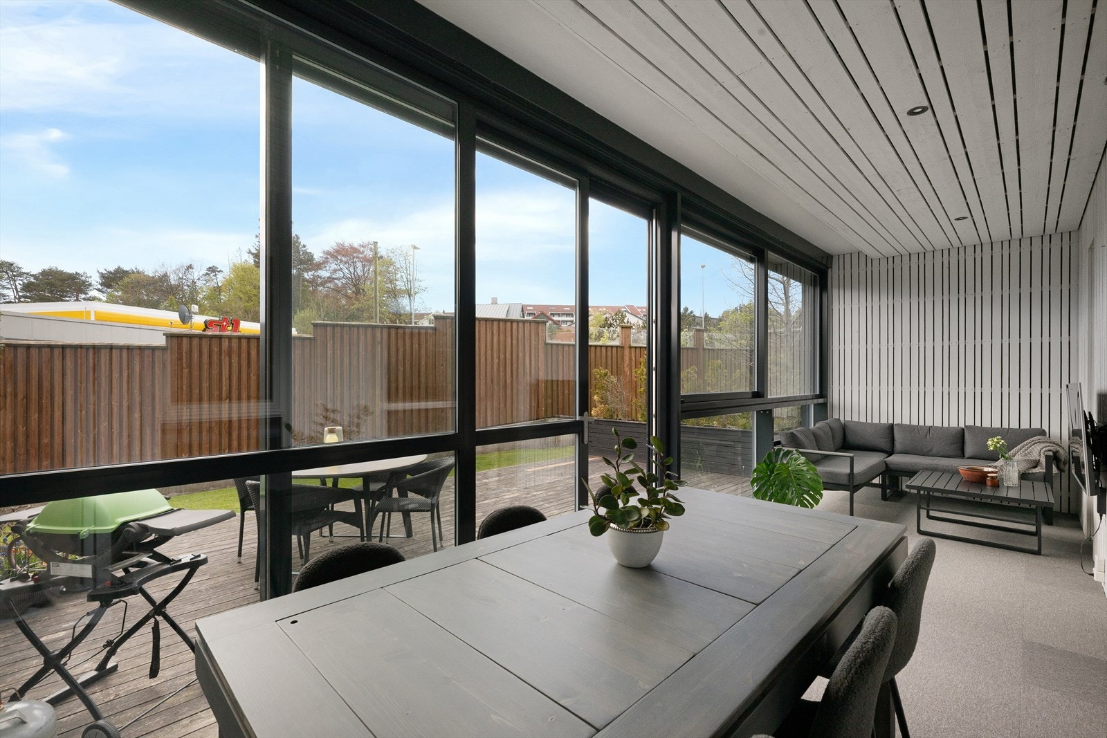 Hagestuen har masse plass til flere soner som tv-stue og spisestue eller lounge. Moderne teppeflis oppå sponplater på gulv. Spotter i tak. Galleribilde