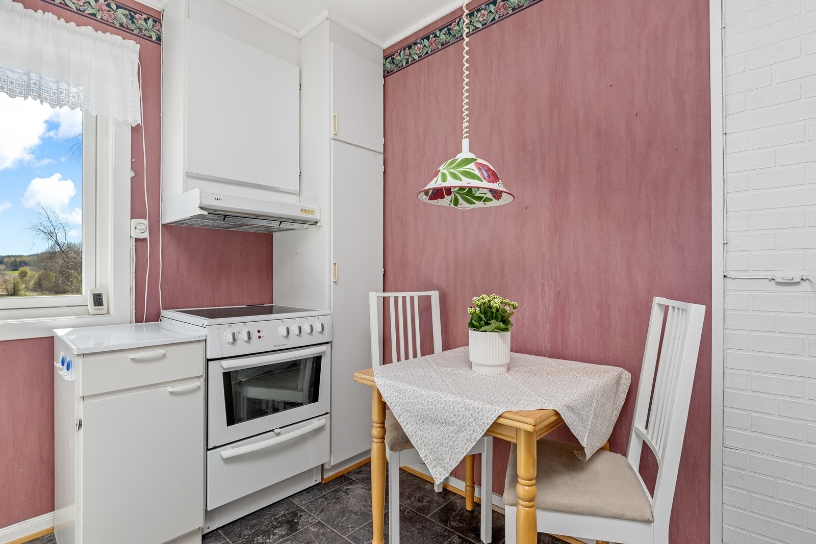 Kjøkken med spiseplass og lyse fronter kombinert med laminert benkeplate. Galleribilde