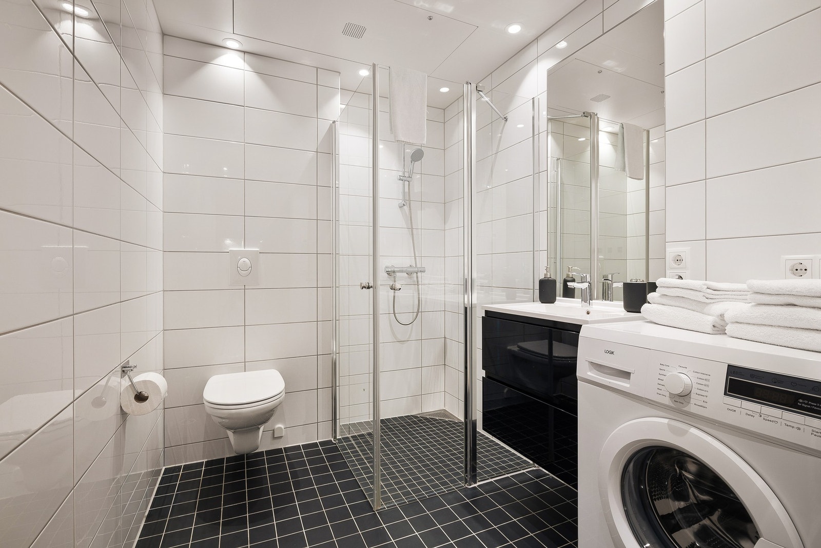 - Badet er lyst og klassisk utført med keramiske fliser på gulv og vegger, gulvvarme og spotlights i himling - Galleribilde