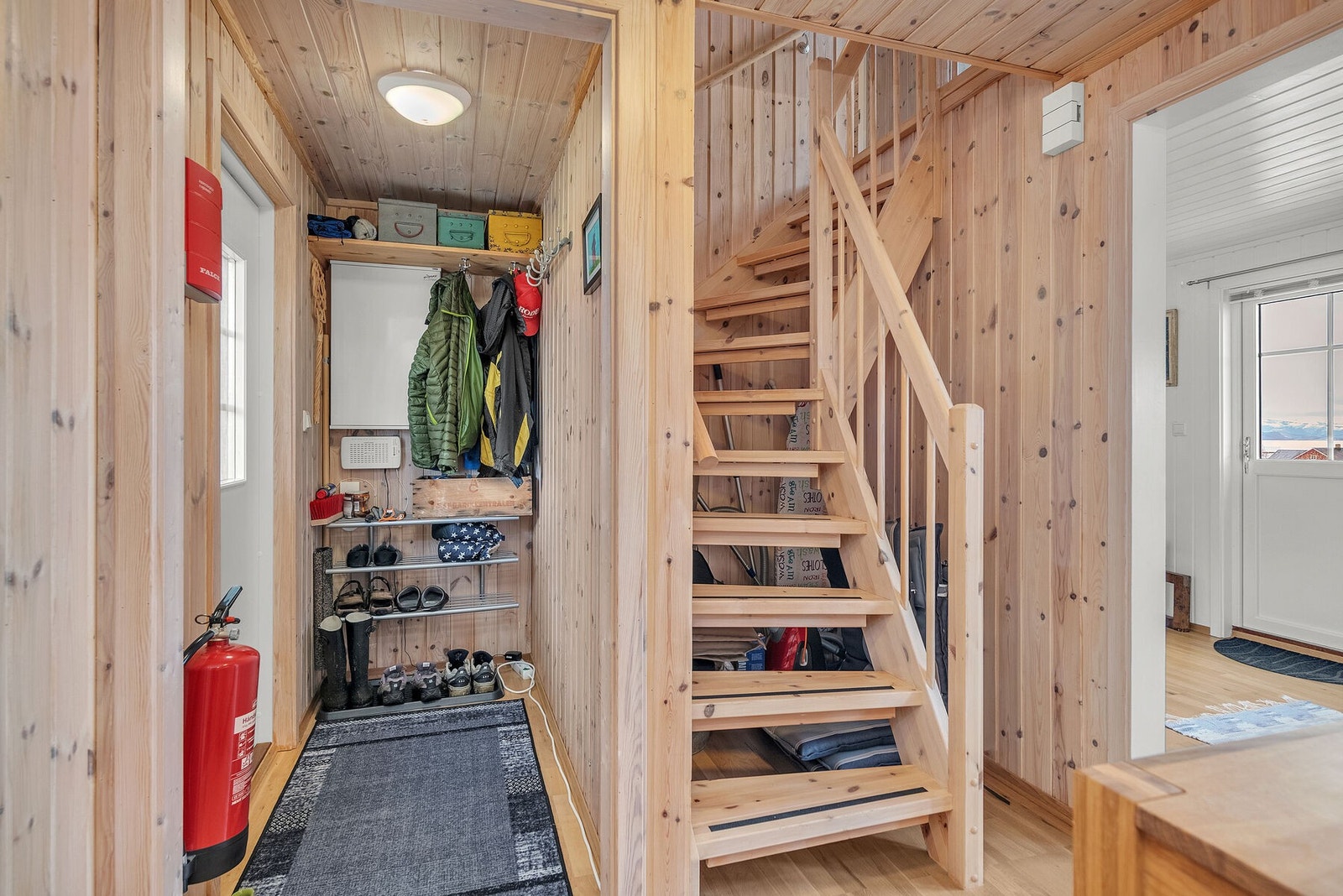 Praktisk entré med plass til oppbevaring av yttertøy og sko, samt trapp til loftsetasjen. Galleribilde