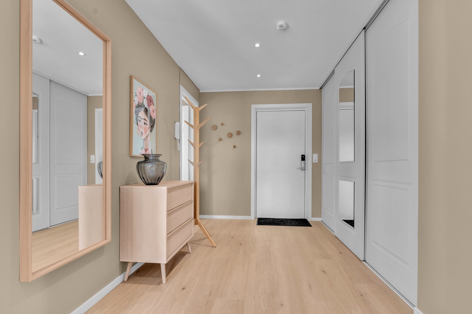 Velkommen inn! Gang med nyere enstavs laminat på gulv, malt gips på veggene og skyvedørsgarderobe. Galleribilde
