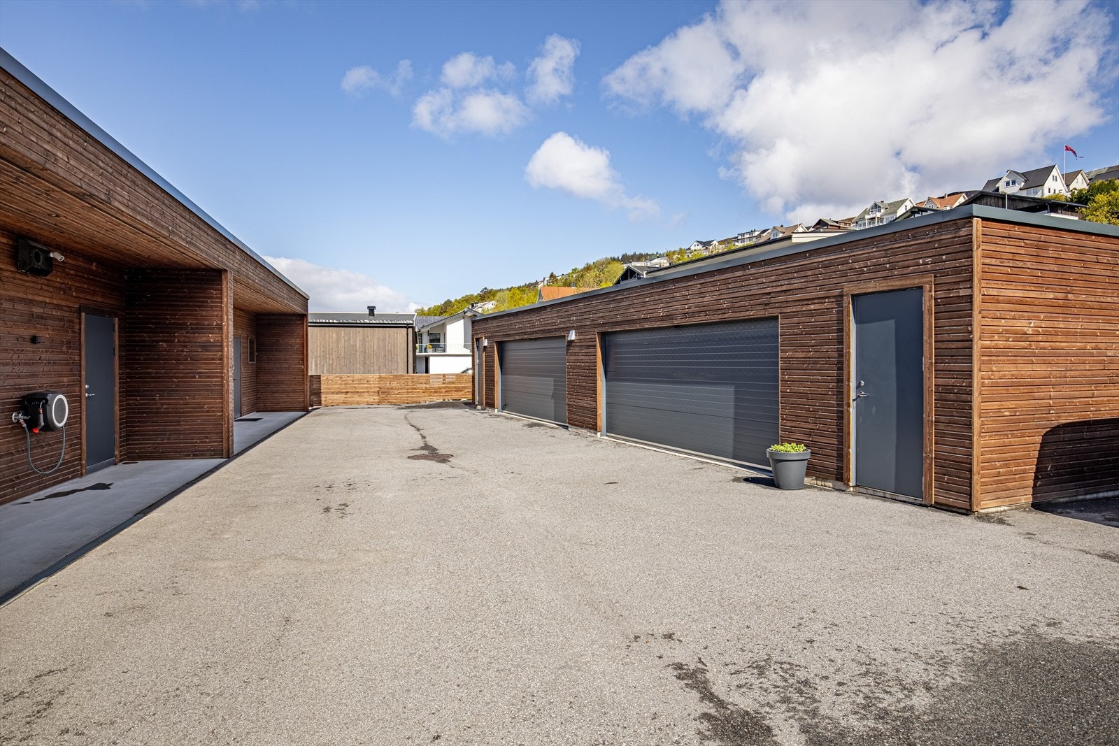 Asfaltert innkjørsel/parkeringsareal og dobbelgarasje med bod. Galleribilde