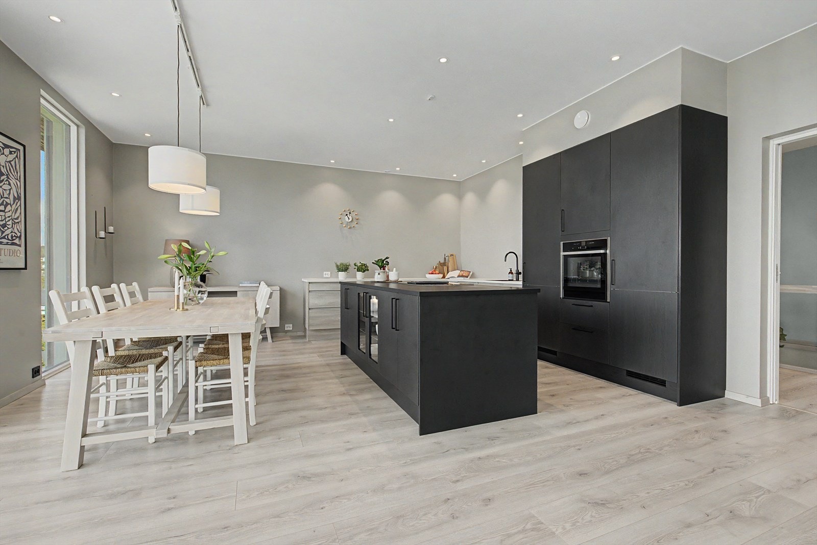 Lekkert og moderne kjøkken med stor øy, integrerte hvitevarer, store benkeflater og mye skapplass. Galleribilde