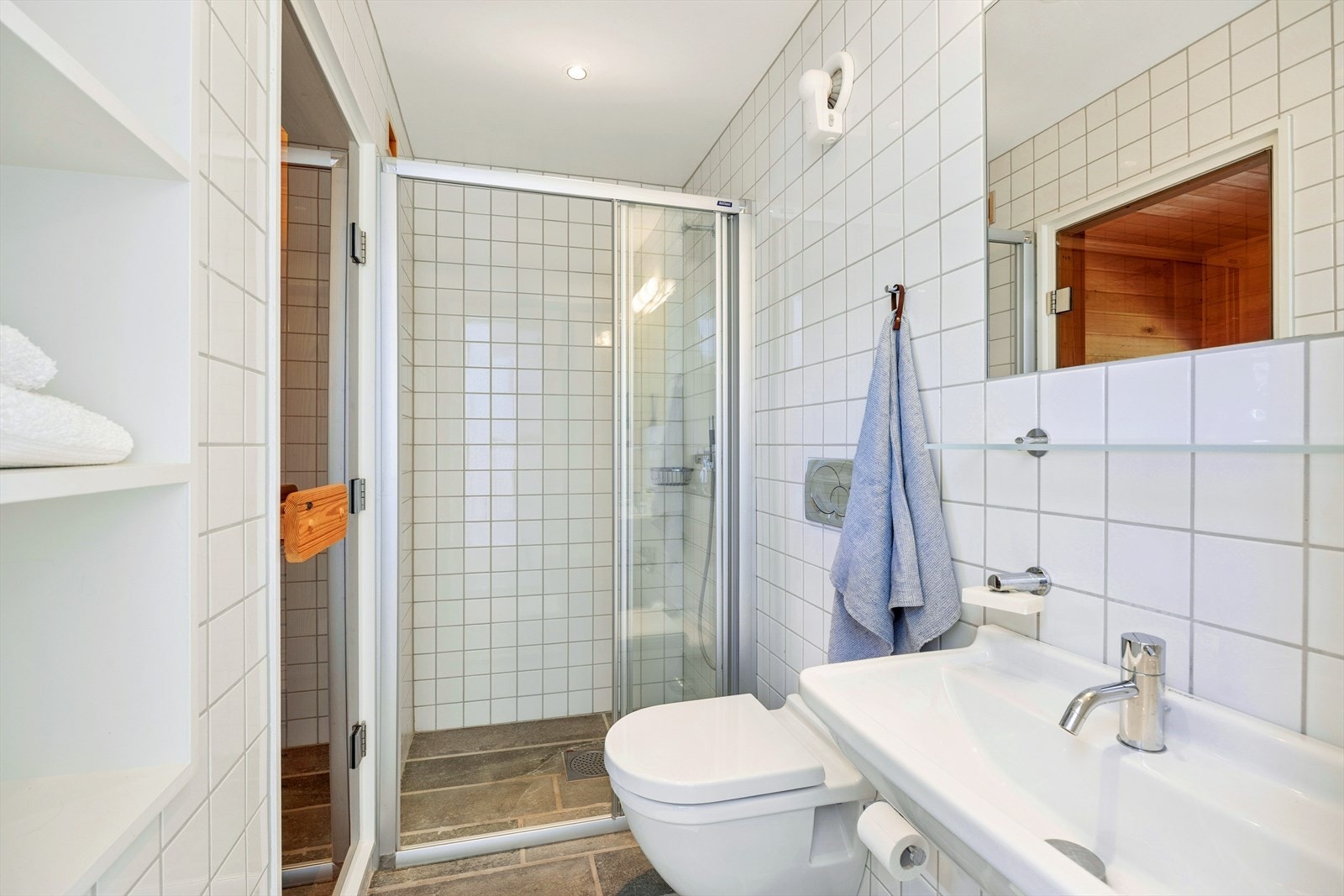 Baderommet i underetasjen med dør til badstuen. Også her er det et innbydende bad med fliser på vegger og gulv. Varmekabler. Galleribilde